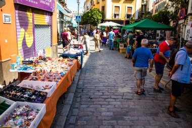 Seville, İspanya - 14 Temmuz 2022 Mercadillo Historico Del Jueves olarak da bilinen bit pazarında satılan çeşitli eşyalar, yerel halk dar Calle Feria 'da pazarlık aramakla meşgul.