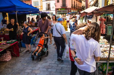 Seville, İspanya - 14 Temmuz 2022 Mercadillo Historico Del Jueves olarak da bilinen bit pazarında satılan çeşitli eşyalar, yerel halk dar Calle Feria 'da pazarlık aramakla meşgul.