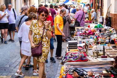 Seville, İspanya - 14 Temmuz 2022 Mercadillo Historico Del Jueves olarak da bilinen bit pazarında satılan çeşitli eşyalar, yerel halk dar Calle Feria 'da pazarlık aramakla meşgul.