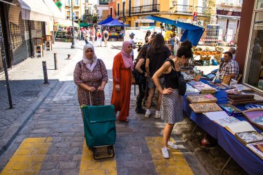 Seville, İspanya - 14 Temmuz 2022 Mercadillo Historico Del Jueves olarak da bilinen bit pazarında satılan çeşitli eşyalar, yerel halk dar Calle Feria 'da pazarlık aramakla meşgul.