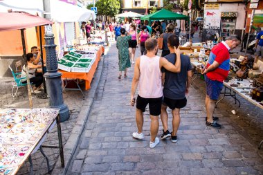 Seville, İspanya - 14 Temmuz 2022 Mercadillo Historico Del Jueves olarak da bilinen bit pazarında satılan çeşitli eşyalar, yerel halk dar Calle Feria 'da pazarlık aramakla meşgul.