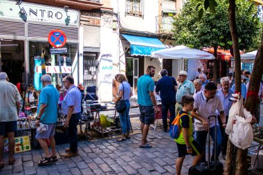 Seville, İspanya - 14 Temmuz 2022 Mercadillo Historico Del Jueves olarak da bilinen bit pazarında satılan çeşitli eşyalar, yerel halk dar Calle Feria 'da pazarlık aramakla meşgul.