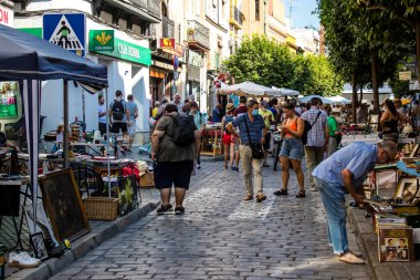 Seville, İspanya - 14 Temmuz 2022 Mercadillo Historico Del Jueves olarak da bilinen bit pazarında satılan çeşitli eşyalar, yerel halk dar Calle Feria 'da pazarlık aramakla meşgul.