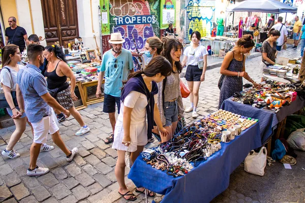Seville, İspanya - 14 Temmuz 2022 Mercadillo Historico Del Jueves olarak da bilinen bit pazarında satılan çeşitli eşyalar, yerel halk dar Calle Feria 'da pazarlık aramakla meşgul.