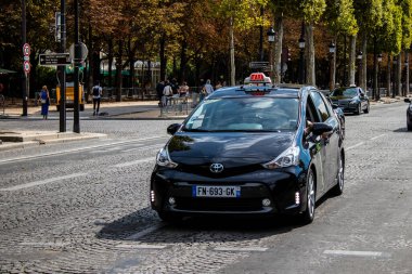Paris, France - September 05, 2022 Taxi driving through the streets of Paris, This mode of transport is famous and widely used by Parisians and tourists, several companies compete in the city of Paris