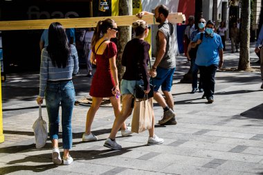 Paris, France - September 05, 2022 Tourists strolling down the famous Avenue Des Champs Elysee in Paris during the coronavirus epidemic which is hitting France, wearing a mask is not mandatory