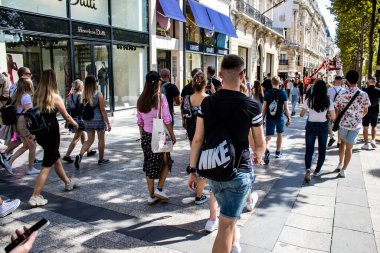 Paris, France - September 05, 2022 Tourists strolling down the famous Avenue Des Champs Elysee in Paris during the coronavirus epidemic which is hitting France, wearing a mask is not mandatory