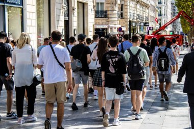 Paris, France - September 05, 2022 Tourists strolling down the famous Avenue Des Champs Elysee in Paris during the coronavirus epidemic which is hitting France, wearing a mask is not mandatory