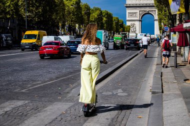 Paris, France - September 05, 2022 People rolling with an electric scooter in the streets of Paris, operating with a small utility internal combustion engines and a deck in the center