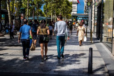 Paris, France - September 05, 2022 Tourists strolling down the famous Avenue Des Champs Elysee in Paris during the coronavirus epidemic which is hitting France, wearing a mask is not mandatory