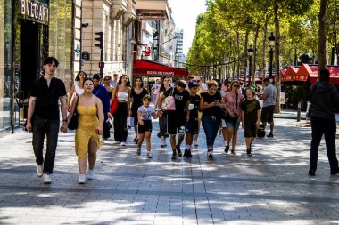 Paris, France - September 05, 2022 Tourists strolling down the famous Avenue Des Champs Elysee in Paris during the coronavirus epidemic which is hitting France, wearing a mask is not mandatory