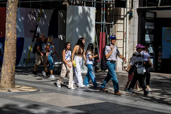 Paris, France - September 05, 2022 Tourists strolling down the famous Avenue Des Champs Elysee in Paris during the coronavirus epidemic which is hitting France, wearing a mask is not mandatory
