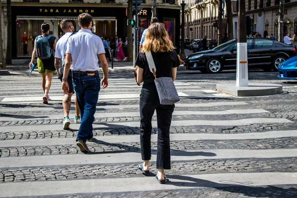 Paris, France - September 05, 2022 Tourists strolling down the famous Avenue Des Champs Elysee in Paris during the coronavirus epidemic which is hitting France, wearing a mask is not mandatory