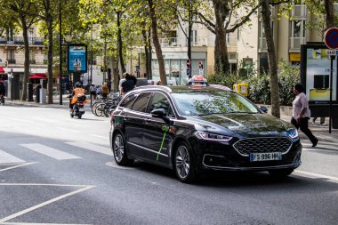 Paris, France - September 05, 2022 Taxi driving through the streets of Paris, This mode of transport is famous and widely used by Parisians and tourists, several companies compete in the city of Paris