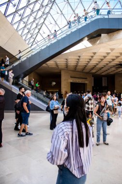 Paris, Fransa - Eylül 2022 Dünyanın en büyük müzesi Louvre, ana girişteki turistler, ziyaretçiler antik heykellere ve ustaların resimlerine hayran olmak için koridorlarda dolaşıyorlar.