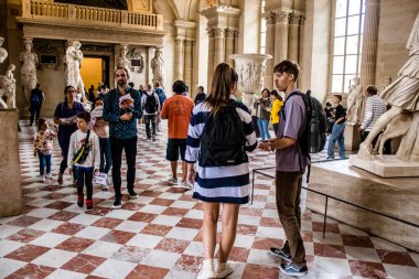 Paris, Fransa - 08 Eylül 2022 Dünyanın en büyük müzesi Louvre, sanat için ikonik bir yer, ziyaretçiler mermer heykellere ve usta resimlere hayran olmak için koridorlarda dolaşıyorlar.