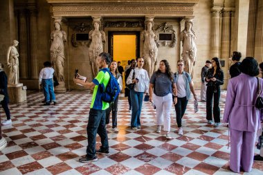 Paris, Fransa - 08 Eylül 2022 Dünyanın en büyük müzesi Louvre, sanat için ikonik bir yer, ziyaretçiler mermer heykellere ve usta resimlere hayran olmak için koridorlarda dolaşıyorlar.