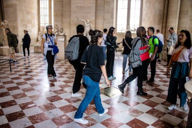Paris, Fransa - 08 Eylül 2022 Dünyanın en büyük müzesi Louvre, sanat için ikonik bir yer, ziyaretçiler mermer heykellere ve usta resimlere hayran olmak için koridorlarda dolaşıyorlar.