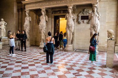Paris, Fransa - 08 Eylül 2022 Dünyanın en büyük müzesi Louvre, sanat için ikonik bir yer, ziyaretçiler mermer heykellere ve usta resimlere hayran olmak için koridorlarda dolaşıyorlar.