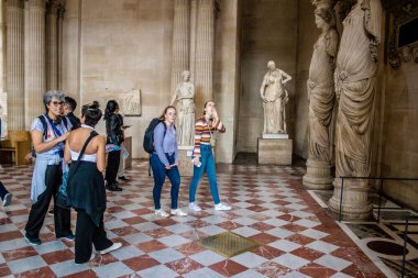 Paris, Fransa - 08 Eylül 2022 Dünyanın en büyük müzesi Louvre, sanat için ikonik bir yer, ziyaretçiler mermer heykellere ve usta resimlere hayran olmak için koridorlarda dolaşıyorlar.