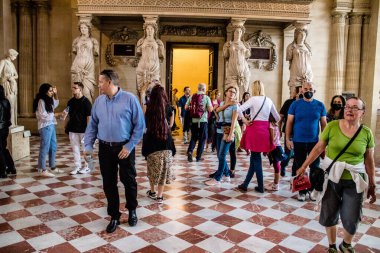 Paris, Fransa - 08 Eylül 2022 Dünyanın en büyük müzesi Louvre, sanat için ikonik bir yer, ziyaretçiler mermer heykellere ve usta resimlere hayran olmak için koridorlarda dolaşıyorlar.