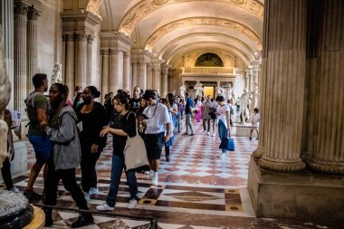 Paris, Fransa - 08 Eylül 2022 Dünyanın en büyük müzesi Louvre, sanat için ikonik bir yer, ziyaretçiler mermer heykellere ve usta resimlere hayran olmak için koridorlarda dolaşıyorlar.