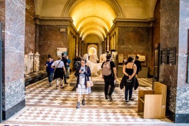 Paris, Fransa - 08 Eylül 2022 Dünyanın en büyük müzesi Louvre, sanat için ikonik bir yer, ziyaretçiler mermer heykellere ve usta resimlere hayran olmak için koridorlarda dolaşıyorlar.