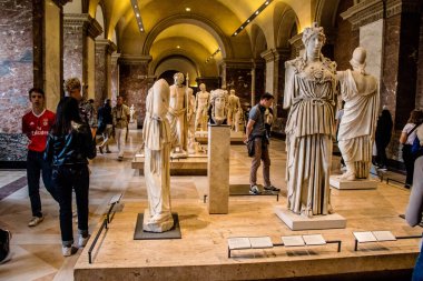 Paris, Fransa - 08 Eylül 2022 Dünyanın en büyük müzesi Louvre, sanat için ikonik bir yer, ziyaretçiler mermer heykellere ve usta resimlere hayran olmak için koridorlarda dolaşıyorlar.