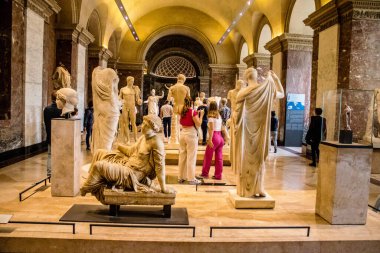 Paris, Fransa - 08 Eylül 2022 Dünyanın en büyük müzesi Louvre, sanat için ikonik bir yer, ziyaretçiler mermer heykellere ve usta resimlere hayran olmak için koridorlarda dolaşıyorlar.