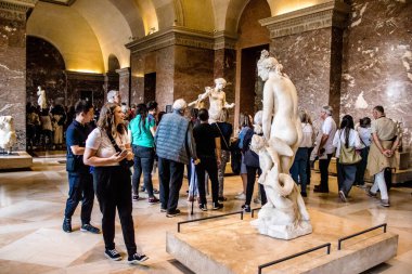Paris, Fransa - 08 Eylül 2022 Dünyanın en büyük müzesi Louvre, sanat için ikonik bir yer, ziyaretçiler mermer heykellere ve usta resimlere hayran olmak için koridorlarda dolaşıyorlar.
