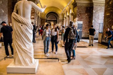 Paris, Fransa - 08 Eylül 2022 Dünyanın en büyük müzesi Louvre, sanat için ikonik bir yer, ziyaretçiler mermer heykellere ve usta resimlere hayran olmak için koridorlarda dolaşıyorlar.