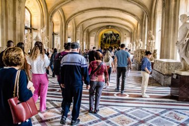 Paris, Fransa - 08 Eylül 2022 Dünyanın en büyük müzesi Louvre, sanat için ikonik bir yer, ziyaretçiler mermer heykellere ve usta resimlere hayran olmak için koridorlarda dolaşıyorlar.