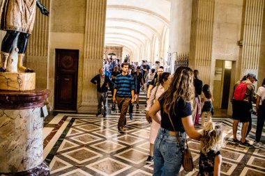 Paris, Fransa - 08 Eylül 2022 Dünyanın en büyük müzesi Louvre, sanat için ikonik bir yer, ziyaretçiler mermer heykellere ve usta resimlere hayran olmak için koridorlarda dolaşıyorlar.