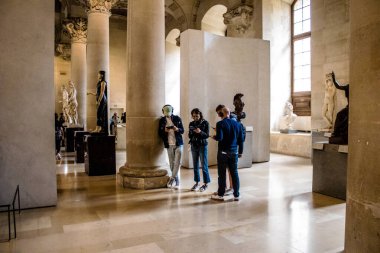 Paris, Fransa - 08 Eylül 2022 Dünyanın en büyük müzesi Louvre, sanat için ikonik bir yer, ziyaretçiler mermer heykellere ve usta resimlere hayran olmak için koridorlarda dolaşıyorlar.