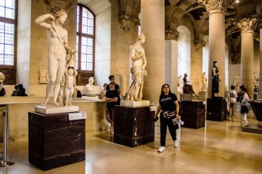 Paris, Fransa - 08 Eylül 2022 Dünyanın en büyük müzesi Louvre, sanat için ikonik bir yer, ziyaretçiler mermer heykellere ve usta resimlere hayran olmak için koridorlarda dolaşıyorlar.
