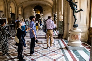 Paris, Fransa - 08 Eylül 2022 Dünyanın en büyük müzesi Louvre, sanat için ikonik bir yer, ziyaretçiler mermer heykellere ve usta resimlere hayran olmak için koridorlarda dolaşıyorlar.