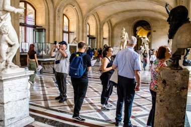 Paris, Fransa - 08 Eylül 2022 Dünyanın en büyük müzesi Louvre, sanat için ikonik bir yer, ziyaretçiler mermer heykellere ve usta resimlere hayran olmak için koridorlarda dolaşıyorlar.