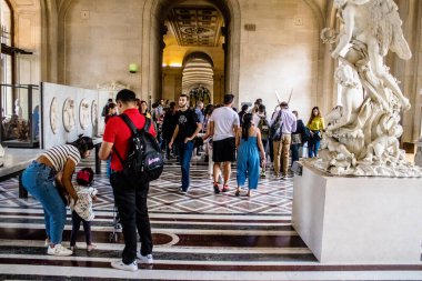 Paris, Fransa - 08 Eylül 2022 Dünyanın en büyük müzesi Louvre, sanat için ikonik bir yer, ziyaretçiler mermer heykellere ve usta resimlere hayran olmak için koridorlarda dolaşıyorlar.