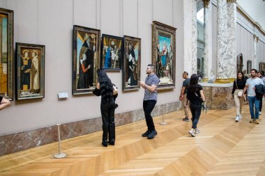 Paris, Fransa - 08 Eylül 2022 Dünyanın en büyük müzesi Louvre, sanat için ikonik bir yer, ziyaretçiler mermer heykellere ve usta resimlere hayran olmak için koridorlarda dolaşıyorlar.