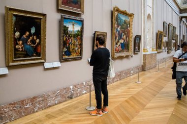 Paris, Fransa - 08 Eylül 2022 Dünyanın en büyük müzesi Louvre, sanat için ikonik bir yer, ziyaretçiler mermer heykellere ve usta resimlere hayran olmak için koridorlarda dolaşıyorlar.