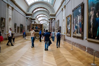 Paris, Fransa - 08 Eylül 2022 Dünyanın en büyük müzesi Louvre, sanat için ikonik bir yer, ziyaretçiler mermer heykellere ve usta resimlere hayran olmak için koridorlarda dolaşıyorlar.