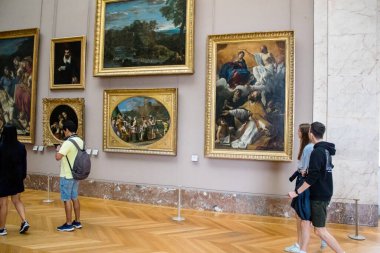 Paris, Fransa - 08 Eylül 2022 Dünyanın en büyük müzesi Louvre, sanat için ikonik bir yer, ziyaretçiler mermer heykellere ve usta resimlere hayran olmak için koridorlarda dolaşıyorlar.