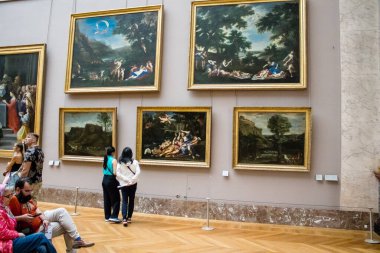 Paris, Fransa - 08 Eylül 2022 Dünyanın en büyük müzesi Louvre, sanat için ikonik bir yer, ziyaretçiler mermer heykellere ve usta resimlere hayran olmak için koridorlarda dolaşıyorlar.