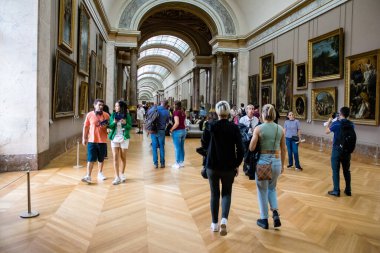 Paris, Fransa - 08 Eylül 2022 Dünyanın en büyük müzesi Louvre, sanat için ikonik bir yer, ziyaretçiler mermer heykellere ve usta resimlere hayran olmak için koridorlarda dolaşıyorlar.