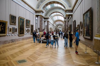 Paris, Fransa - 08 Eylül 2022 Dünyanın en büyük müzesi Louvre, sanat için ikonik bir yer, ziyaretçiler mermer heykellere ve usta resimlere hayran olmak için koridorlarda dolaşıyorlar.