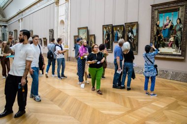 Paris, Fransa - 08 Eylül 2022 Dünyanın en büyük müzesi Louvre, sanat için ikonik bir yer, ziyaretçiler mermer heykellere ve usta resimlere hayran olmak için koridorlarda dolaşıyorlar.