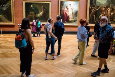 Paris, Fransa - 08 Eylül 2022 Dünyanın en büyük müzesi Louvre, sanat için ikonik bir yer, ziyaretçiler mermer heykellere ve usta resimlere hayran olmak için koridorlarda dolaşıyorlar.