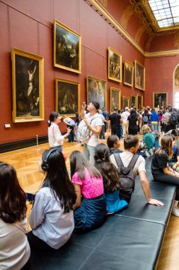 Paris, Fransa - 08 Eylül 2022 Dünyanın en büyük müzesi Louvre, sanat için ikonik bir yer, ziyaretçiler mermer heykellere ve usta resimlere hayran olmak için koridorlarda dolaşıyorlar.