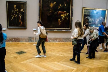 Paris, Fransa - 08 Eylül 2022 Dünyanın en büyük müzesi Louvre, sanat için ikonik bir yer, ziyaretçiler mermer heykellere ve usta resimlere hayran olmak için koridorlarda dolaşıyorlar.