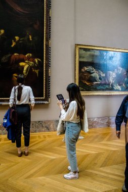 Paris, Fransa - 08 Eylül 2022 Dünyanın en büyük müzesi Louvre, sanat için ikonik bir yer, ziyaretçiler mermer heykellere ve usta resimlere hayran olmak için koridorlarda dolaşıyorlar.